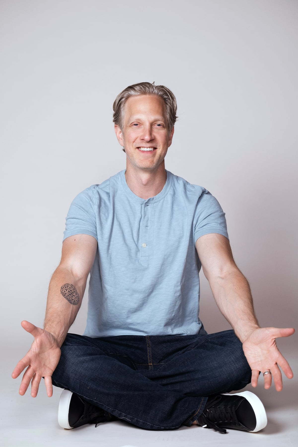 Randy seated and smiling in a blue shirt