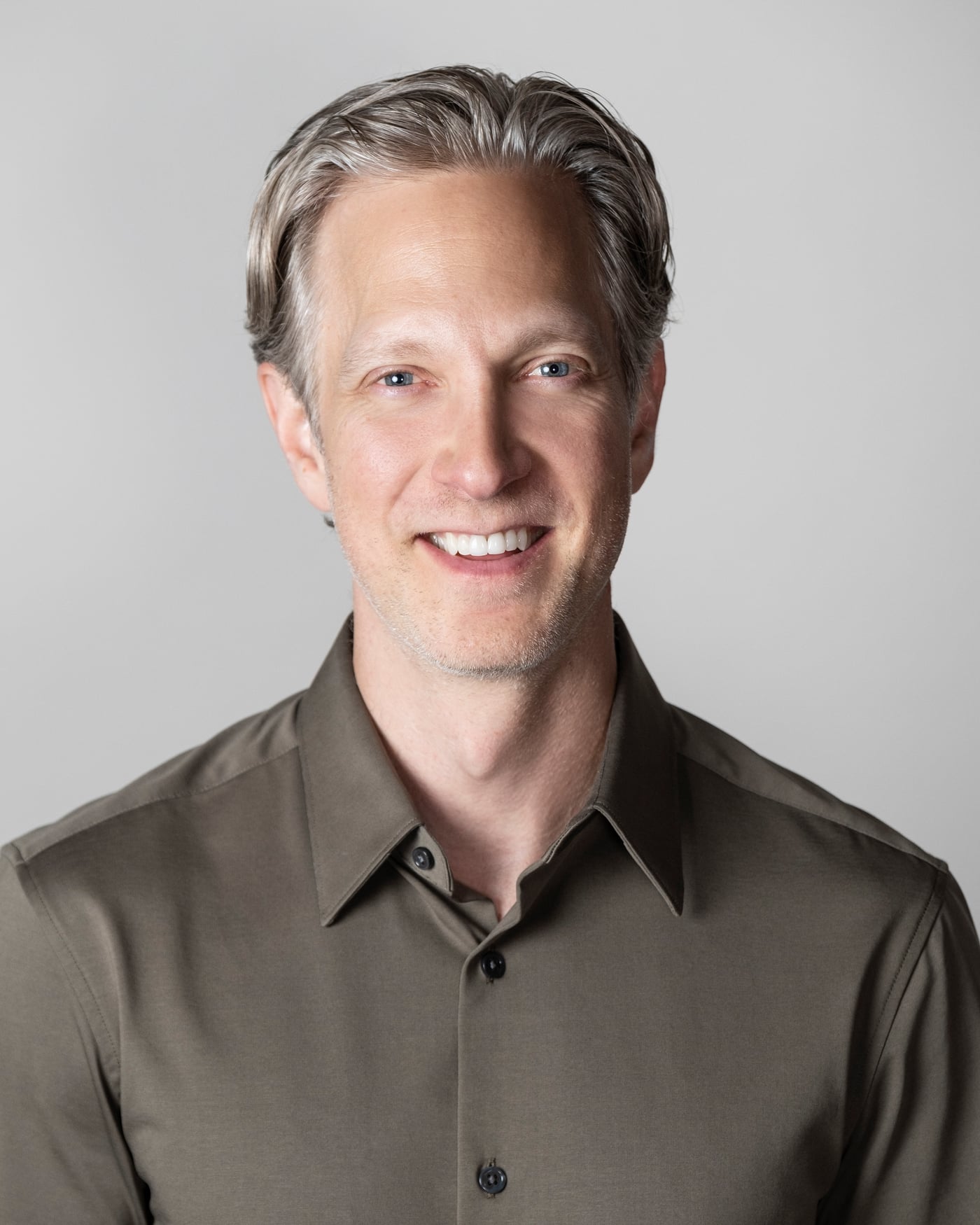 Randy smiling at the camera in a dark collared shirt