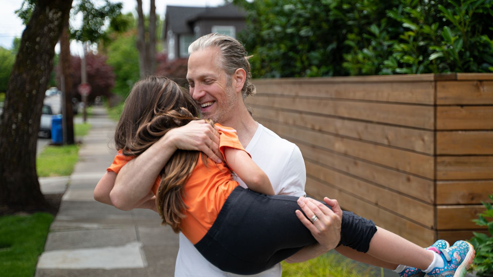 Randy carrying his daughter outdoors