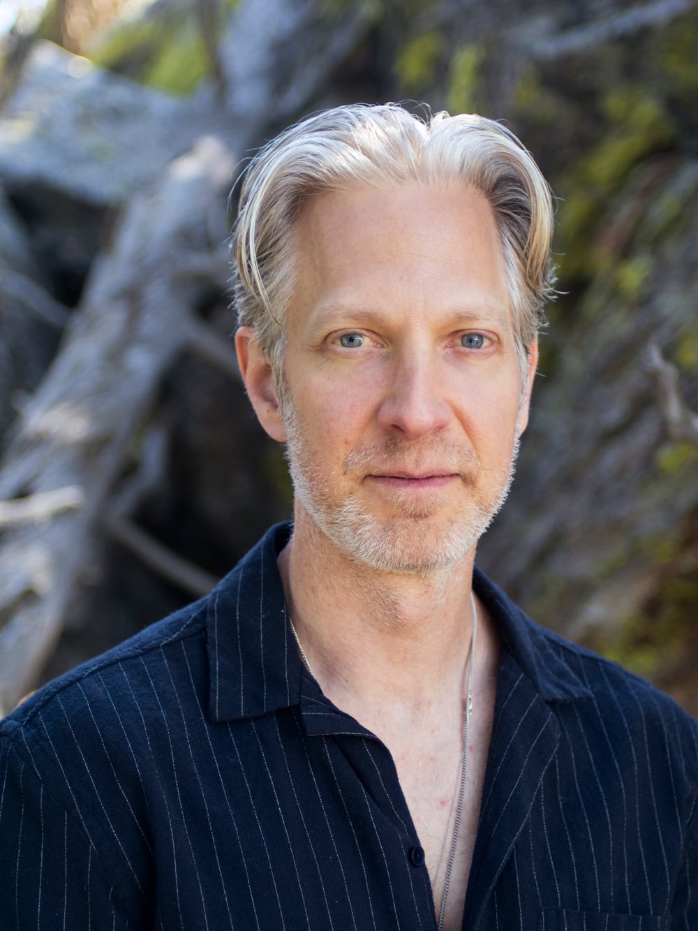 Randy outdoors in a navy striped shirt